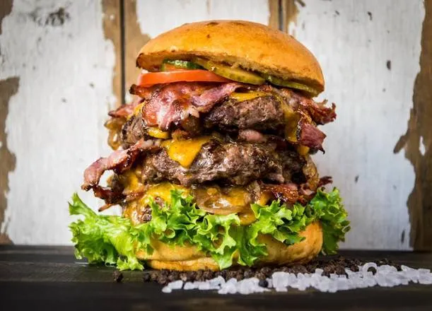 Hoher Mount Feuersteins Burger mit mehreren Schichten und Salat